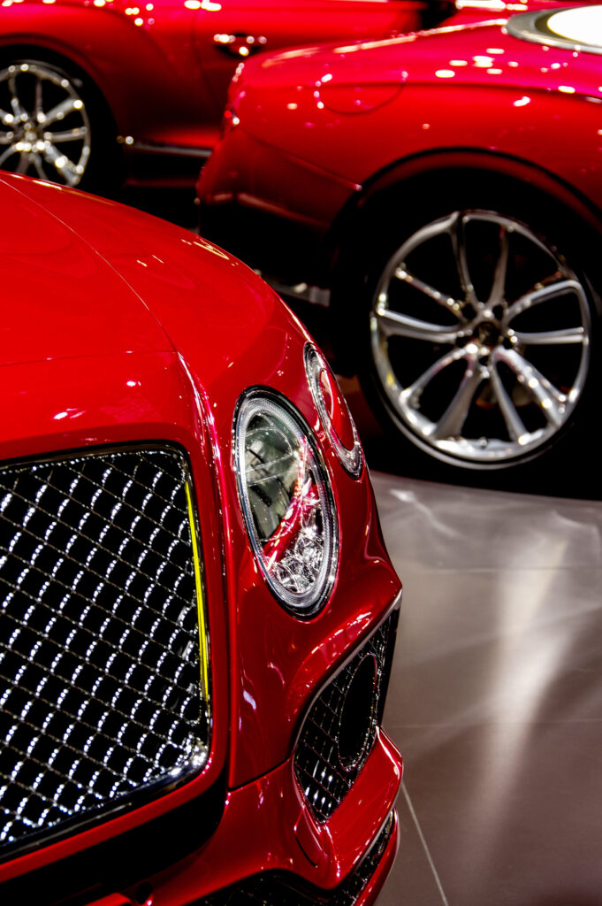a red bentley in a showroom