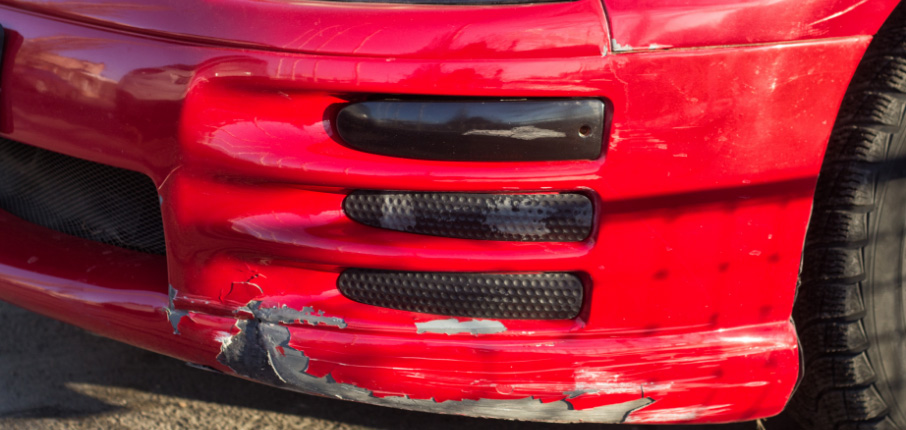 Broken car bumper of lowered suspension red sport car