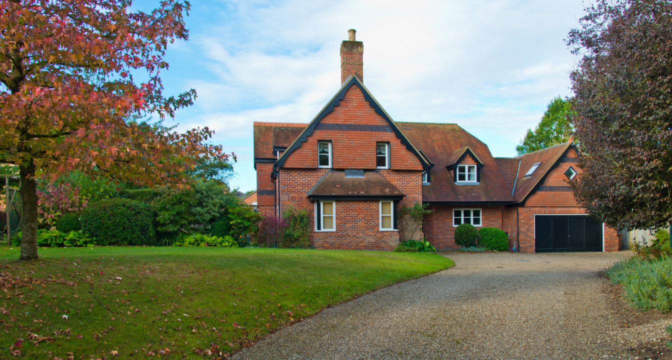 a high-value home with a large driveway and garden